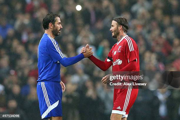 David Beckham of Great Britain and Ireland shakes hands with Robert Pires of the Rest of the World as he is substituted in the second half during the...