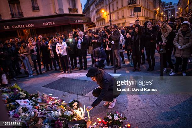 Mourner leaves a candles in front of the Petit Cambodge restaurant with the Le Carillon restaurant on the background on November 14, 2015 in Paris,...