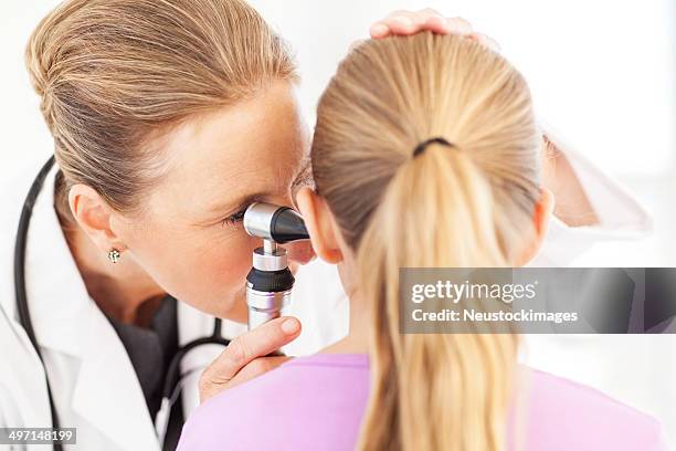 medico di orecchio di analisi ragazza con otoscopio - medical examination of young foto e immagini stock