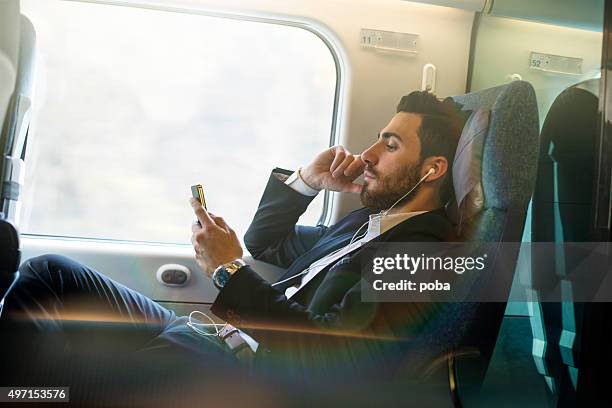 bussinesman seating on a train beside window and using phone - well dressed stock pictures, royalty-free photos & images