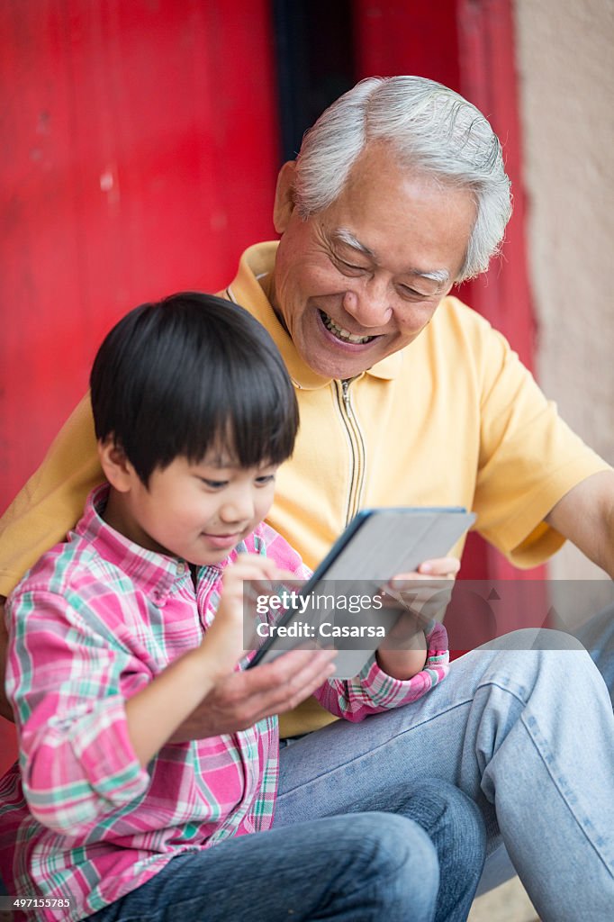 Nieto mostrando abuelo su tableta Digital