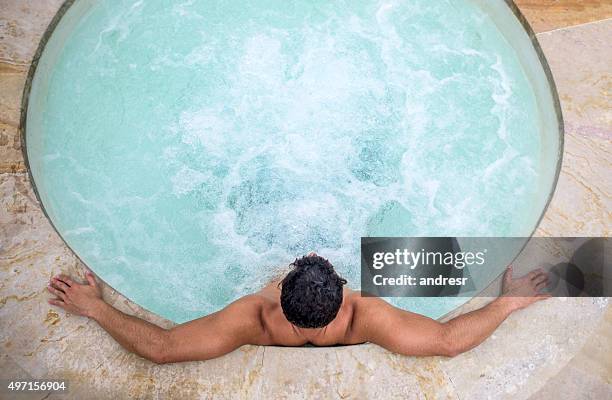 homme se relaxant dans un bain à remous - bain à remous photos et images de collection