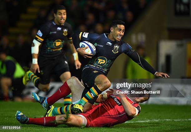 Ken Pisi of Northampton crashes over the tryline to score the opening try despite the tackle from Hadleigh Parkes of Scarlets during the European...