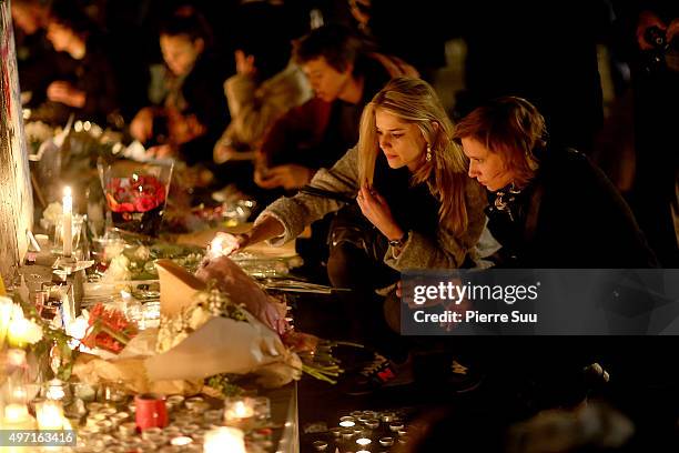 Woman lights a candle at a spontaneous gathering of Parisians at Place de la Republique on November 14, 2015 in Paris, France. At least 120 people...