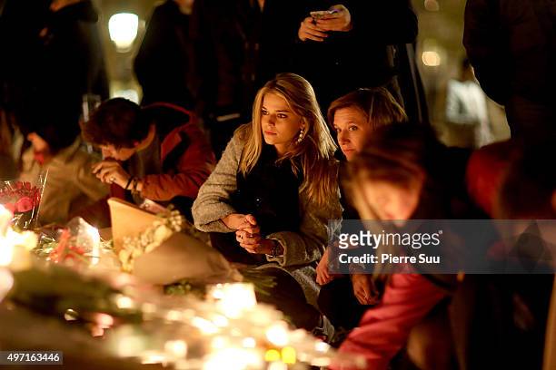 Woman lights a candle at a spontaneous gathering of Parisians at Place de la Republique on November 14, 2015 in Paris, France. At least 120 people...