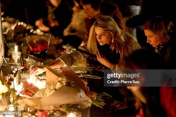 Woman lights a candle at a spontaneous gathering of Parisians at Place de la Republique on November 14, 2015 in Paris, France. At least 120 people...
