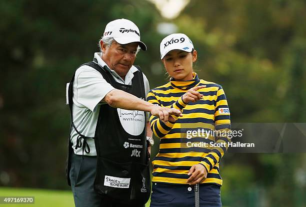 Sakura Yokomine of Japan chats with her caddie on the 17th hole during the third round of the Lorena Ochoa Invitational Presented By Banamex at the...