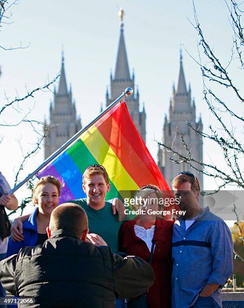 Standing in front of a pride flag with the historic Mormon Temple in the background people have their picture taken after they resign from the Church...