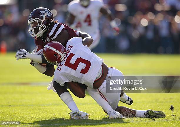 De'Runnya Wilson of the Mississippi State Bulldogs pulls in this reception as he is tackled by Cyrus Jones of the Alabama Crimson Tide at Davis Wade...