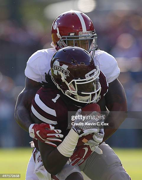 De'Runnya Wilson of the Mississippi State Bulldogs pulls in this reception as he is tackled by Cyrus Jones of the Alabama Crimson Tide at Davis Wade...
