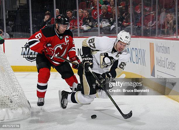 Andy Greene of the New Jersey Devils checks Sidney Crosby of the Pittsburgh Penguins during the first period at the Prudential Center on November 14,...