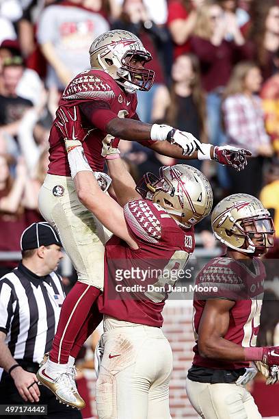 Wide Receiver Kermit Whitfield is lifted up by teammate Tight End Ryan Izzo of the Florida State Seminoles after a score during the game against the...