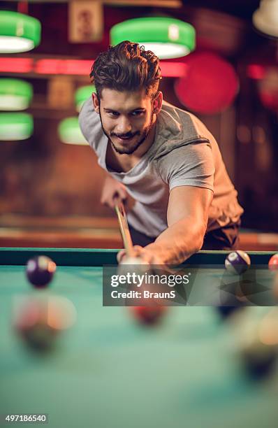 smiling man enjoying in a pool game at pub. - billiard ball game stockfoto's en -beelden