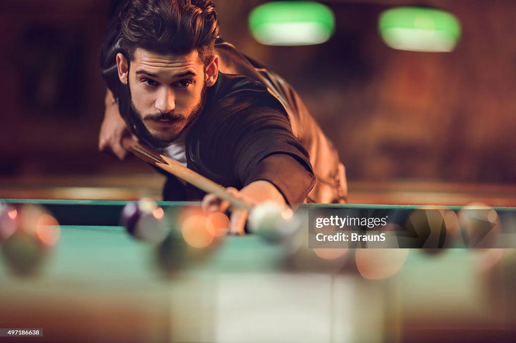 Junger Mann spielen Sie Billard in einem pool hall.