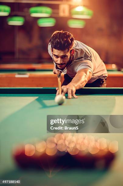 young smiling man playing snooker in a pub. - pool table stock pictures, royalty-free photos & images