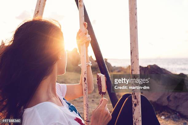 girl swinging at sunset - sun flare on glass bildbanksfoton och bilder