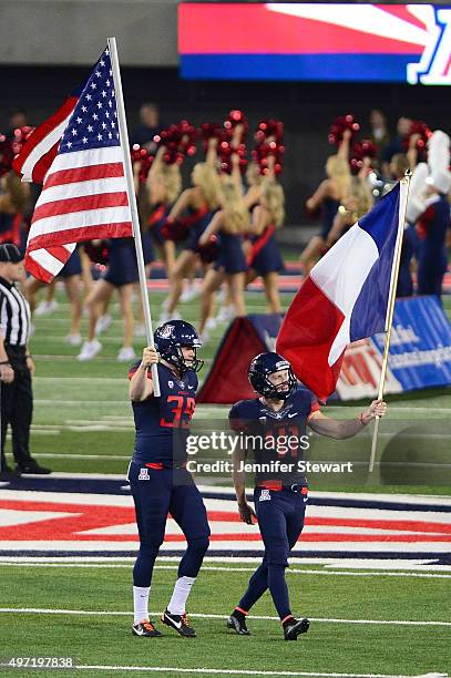 Punter Drew Riggleman and place kicker Casey Skowron of the Arizona Wildcats carry out the American and French flag prior to the game against the...