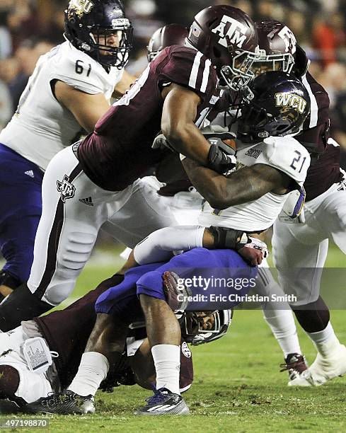 Detrez Newsome of the Western Carolina Catamounts is tackled at the line of scrimmage by Daeshon Hall and Josh Walker of the Texas A&M Aggies in the...