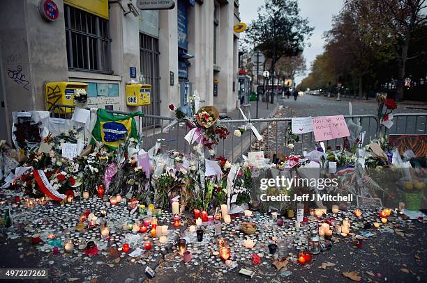 Floweres, candles and tributes cover the pavement near the scene of Friday's Bataclan Theatre terrorist attack on November 15, 2015 in Paris, France....