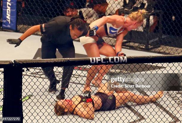 Referee Herb Dean ends the fight as New UFC women's bantamweight champion Holly Holm of the United States starts to celebrate her victory over Ronda...