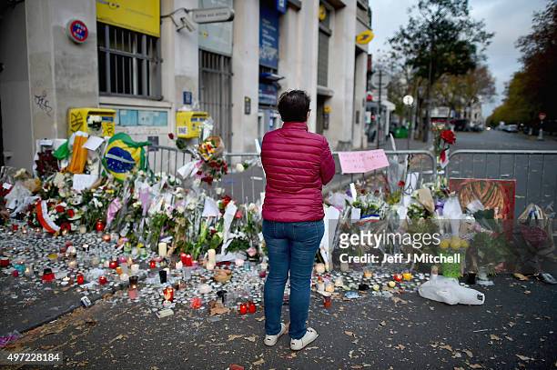 Members of the public view flowers and tributes on the pavement near the scene of Friday's Bataclan Theatre terrorist attack on November 15, 2015 in...
