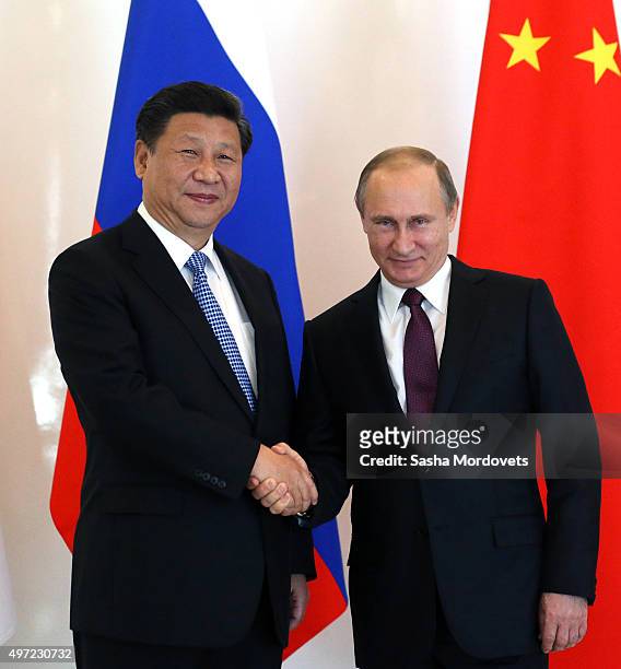 Russian President Vladimir Putin greets Chinese President Xi Jinping during the BRICS leaders meeting prior to G20 Antalya Summit in Belek, near...