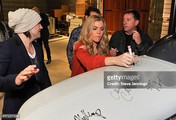 Neil Perry, Kimberly Perry of The Band Perry autograph a Porsche tractor for Tim Bucher President of Trattore Farms at the GRAMMY Foundation house...