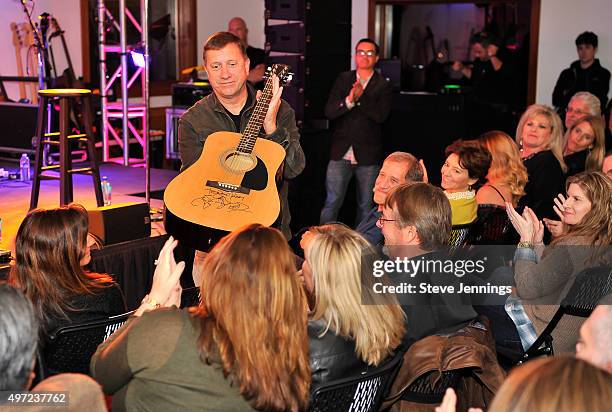 Tim Bucher, President of Trattore Farms congradulates a guest biding on an auctioned autographed guitar by The Band Perry at the GRAMMY Foundation...