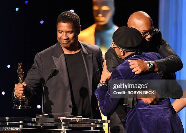 Director Spike Lee gets a bear hug from actor Samuel L. Jackson as he accepts his honorary Oscar from Jackson and actor Denzel Washington , on stage...