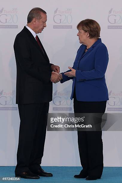 Turkish President Recep Tayyip Erdogan talks with Germany's Chancellor Angela Merkel during the official welcome ceremony on day one of the G20...