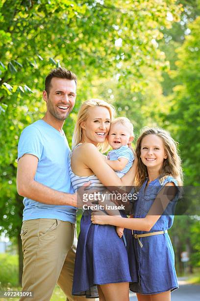glückliche familie in einem park - baby lachen natur stock-fotos und bilder
