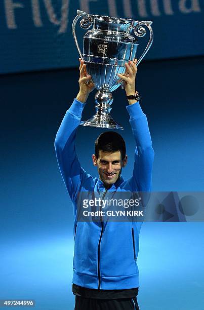 Serbia's Novak Djokovic holds the trophy of the ATP World No 1 Award after it was presented to him following his men's singles group stage match...
