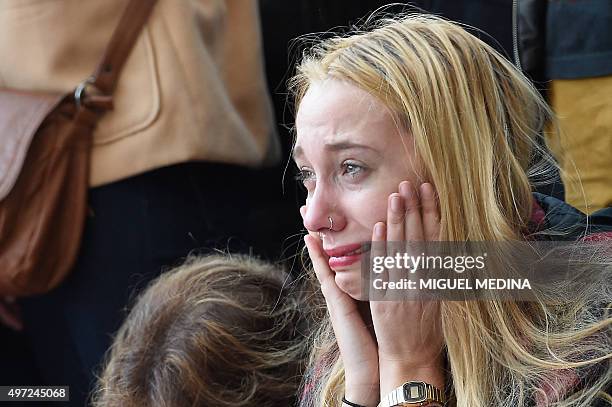 Woman reacts at a makeshift memorial near the Bataclan concert hall in Paris on November 15 two days after a series of deadly attacks. Islamic State...