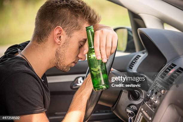 man drinking beer while driving a car - alcoholisme stockfoto's en -beelden