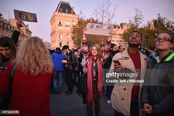 Woman holds a sign offering free hugs as people gather at Place de la Republique as France observes three days of national mourning for the victims...