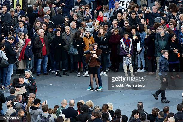 People embrace as they gather to mourn the victims of the terrorist attacks, at the Place de La Republique square on November 15, 2015 in Paris,...