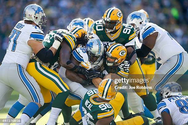 Joique Bell of the Detroit Lions carries the football against Clay Matthews and B.J. Raji of the Green Bay Packers in the first quarter at Lambeau...