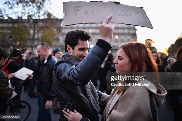 Man holds a sign offering free hugs at Place de la Republique as France observes three days of national mourning for the victims of the terror...