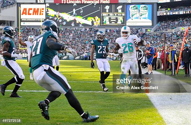 Lamar Miller of the Miami Dolphins scores a second quarter touchdown reception against Malcolm Jenkins and Nolan Carroll of the Philadelphia Eagles...