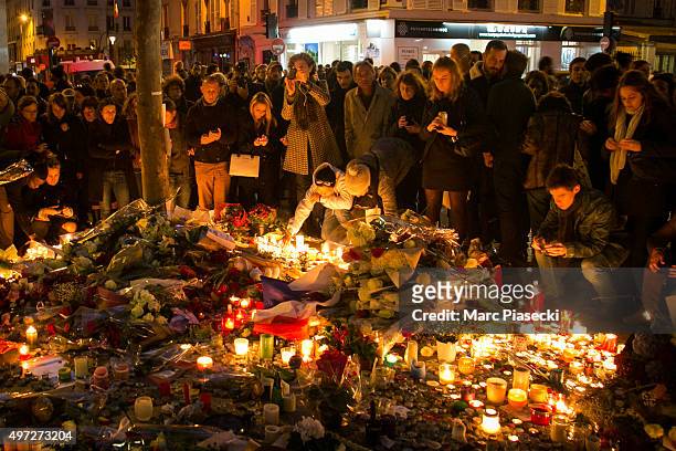 Crowds gather as candles are lit near the Bataclan theatre as France observes three days of national mourning on November 15, 2015 in Paris, France....