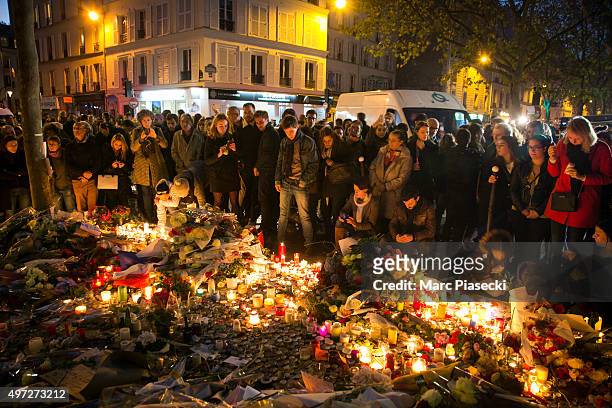 Crowds gather as candles are lit near the Bataclan theatre as France observes three days of national mourning on November 15, 2015 in Paris, France....