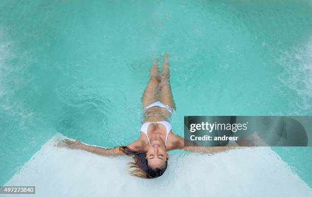 belle femme se relaxant à la piscine - spa treatment photos et images de collection