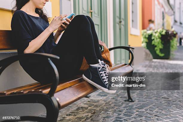 girl text messaging on the phone - converse sports shoe stock pictures, royalty-free photos & images