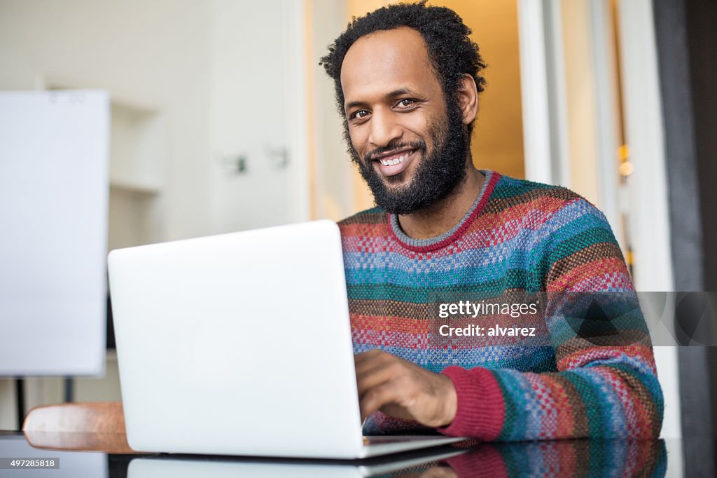 Happy african man working at his desk