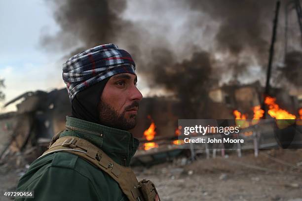 Kurdish Peshmerga soldier passes by tires set afire days before by ISIL extremists to hinder airstrikes on November 15, 2015 in Sinjar, Iraq. Kurdish...