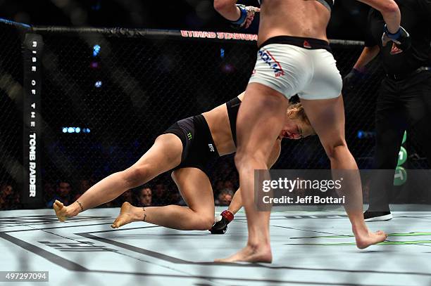 Ronda Rousey falls to the mat as she is knocked out by Holly Holm in their UFC women's bantamweight championship bout during the UFC 193 event at...