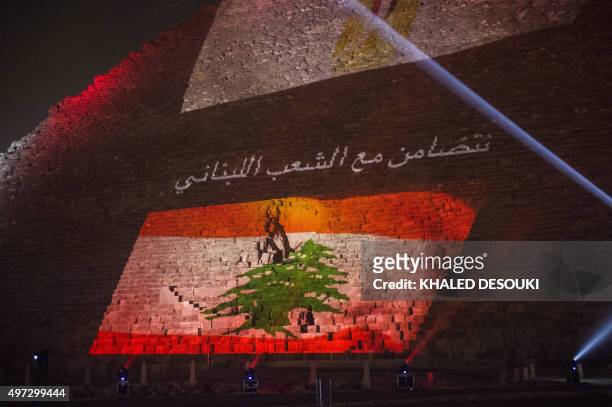 Picture taken on November 15, 2015 shows the great pyramid of Khufu illuminated with the Lebanese flag in Giza, outskirt of Cairo, during a ceremony...