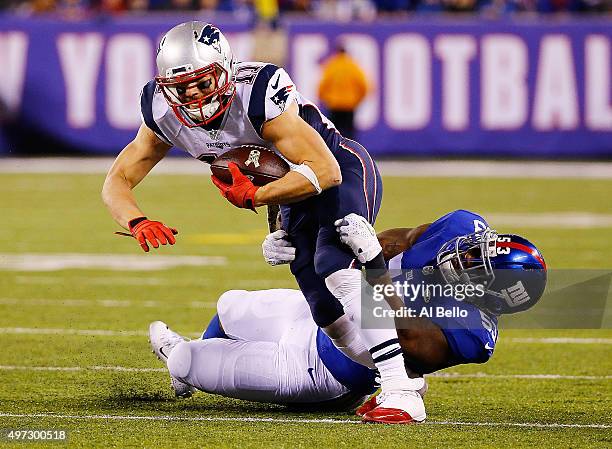 Julian Edelman of the New England Patriots is wrapped up by Jasper Brinkley of the New York Giants during the first quarter at MetLife Stadium on...