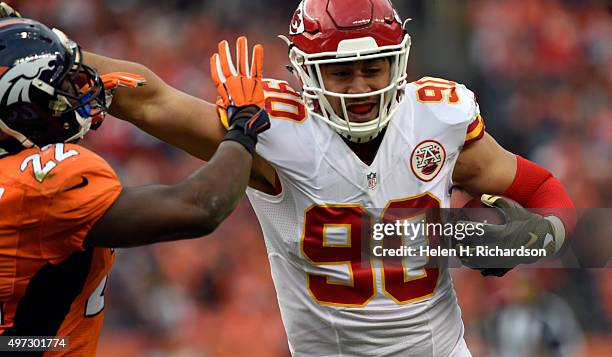 Inside linebacker Josh Mauga of the Kansas City Chiefs fends off running back C.J. Anderson of the Denver Broncos after intercepting Peyton Manning...