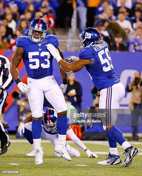 Jasper Brinkley of the New York Giants and his teammate Devon Kennard celebrate a tackle against the New England Patriots during the third quarter at...